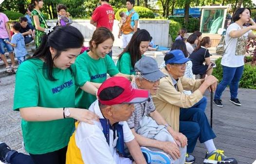 공원에서 어르신들 곁에 앉아 이야기를 듣는 수강생들