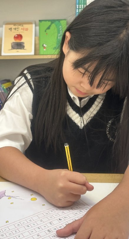 연필로 글을 쓰는 아이